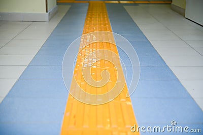 Perspective yellow tactile strip for cane or foot of blind person Stock Photo