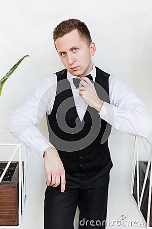 Perspective young man, future generation of businessman stand near green plant on white background Stock Photo