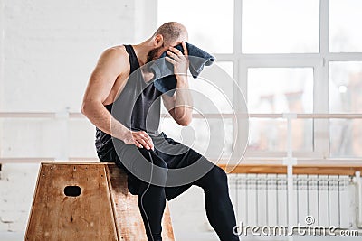 Perspiring fit sportsman resting after work session cross workout in light hall Stock Photo