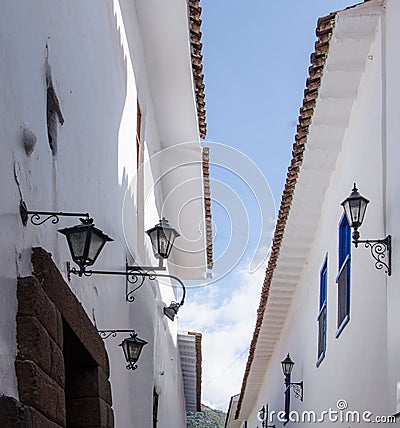 Peru, May, Cusco white walls, blue rectangular framed windows, walls converge to narrow opening to blue sky Stock Photo