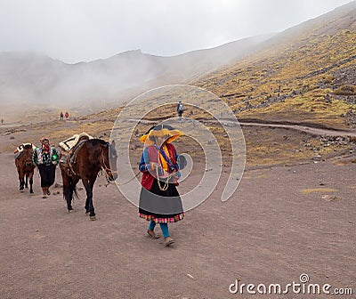 Indians leading horses walk on dirt road dressed in colorful traditional clothes Editorial Stock Photo