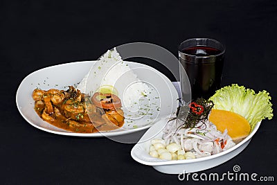 PERUVIAN FOOD: Lunch Cebiche and Picante de Mariscos with rice and a glass of chicha morada Stock Photo