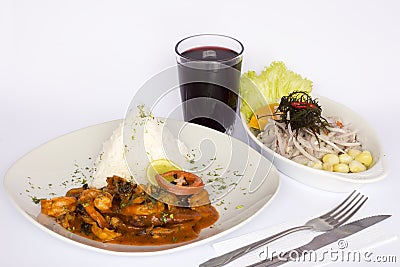 PERUVIAN FOOD: Lunch Cebiche and Picante de Mariscos with rice and a glass of chicha morada Stock Photo