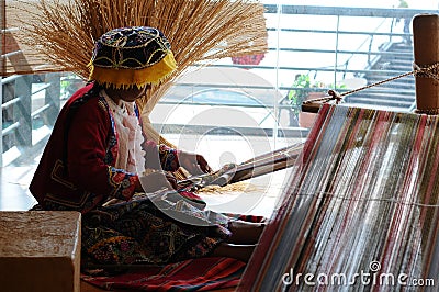Peruvian indigenous woman is weaving a carpet. Editorial Stock Photo
