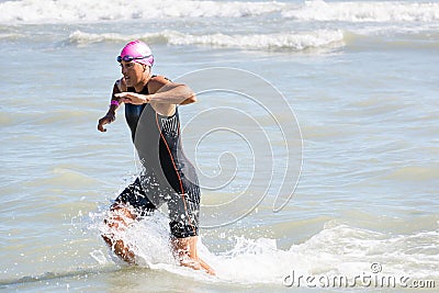 Arrival of the first athletes at the end of the swimming test at Ironman 70.3 in Pescara Editorial Stock Photo