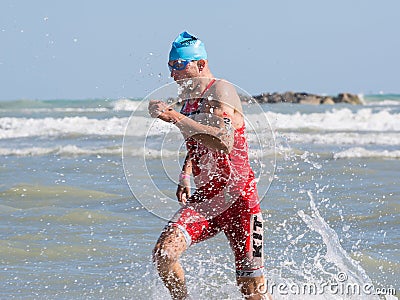 Arrival of the first athletes at the end of the swimming test at Ironman 70.3 in Pescara Editorial Stock Photo