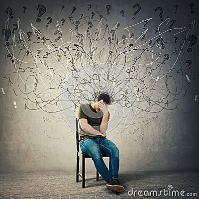 Pessimistic, disappointed man sitting on a chair in a dark room, suffer anxiety, distress depression feeling Stock Photo