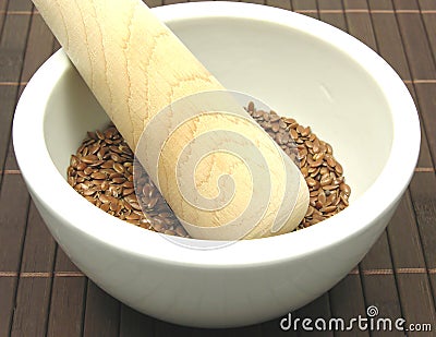 Pestling brown flaxseed Stock Photo