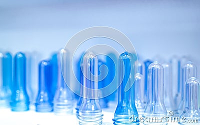 PET bottle preforms before blow molding, filling and labeling process. Blue PET bottle preforms for beverage industry. Raw Stock Photo