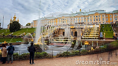 PETERGOF, SAINT PETERSBURG, RUSSIA - SEPTEMBER 18, 2016: Tourist admiring the Samson Fountain, the Grand Cascade and the Peterhof Editorial Stock Photo