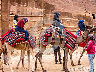 PETRA, JORDAN: Group of tourists on camels in Petra Rose City Editorial Stock Photo