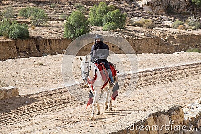 Bedouin riding a horse in Petra archaeological park at cold winter day Editorial Stock Photo