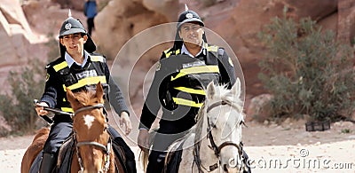 Petra, Wadi Musa, Jordan, March 9. 2018: Two policemen on horseback with funny pimple hoods and signal vests to protect the many i Editorial Stock Photo