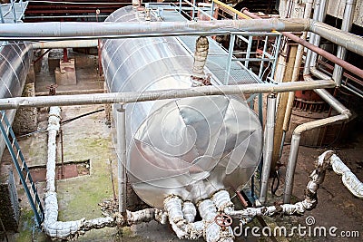 Petrochemical production equipment. Horizontal storage tank storage barrel of chemical plant surrounded by pipeline valves and Stock Photo