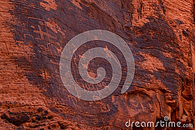Petroglyphs of an ancient people carved on red sandstone in the Valley of Fire, Nevada, USA. Glyph symbols as means of Stock Photo