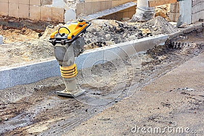 Petrol vibratory rammer is located at the workplace of the construction site Stock Photo