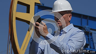 Petroleum Engineer Working in Extracting Oil Industry Using Mobile Phone Communi Stock Photo
