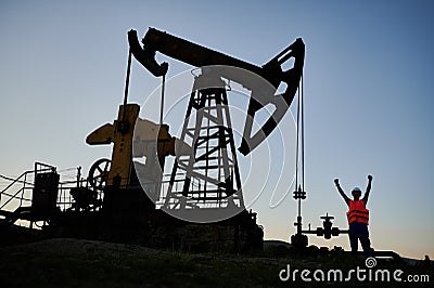Male worker using petroleum pump jack in oil field. Stock Photo