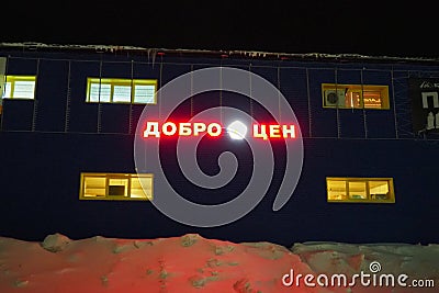 Petrozavodsk, Karelia, Russia, January 11, 2024: building - hangar of the Dobrotsen store, at night in winter. Red Editorial Stock Photo