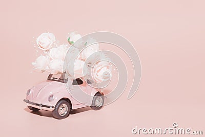 Petrozavodsk, Russia - April 04, 2019: Pink retro toy car with bouquet of white Roses on pink background. Concept Valentine`s day Editorial Stock Photo