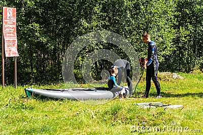 Family in wetsuits near an inflatable boat Editorial Stock Photo