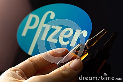 Pfizer coronavirus vaccine pharmaceutical corporation. Logo and hand with vaccine Editorial Stock Photo