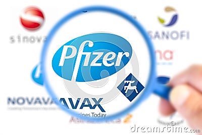 Pfizer logotype enlarged with a magnifying glass with other logotype laboratories on blurry background Editorial Stock Photo