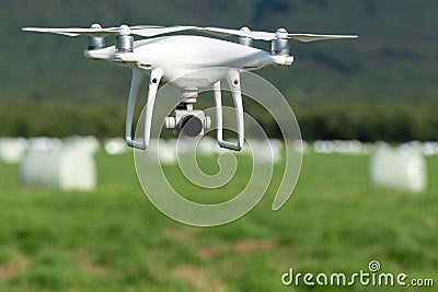 Phantom 4 Pro quadcopter drone flight, monitoring and filming using camera 4K over field with haystack rolls on dry weather Editorial Stock Photo