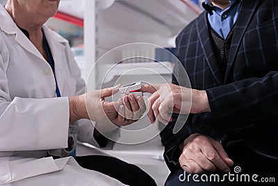 Pharmaceutical employee measuring customer oxygen saturation and giving consultation Stock Photo