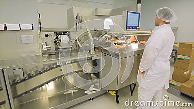 Pharmaceutical industry. Male factory worker inspecting quality of pills packaging in pharmaceutical factory. Automatic Editorial Stock Photo