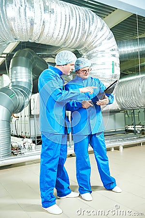 Pharmaceutical male workers in water preparation production line Stock Photo