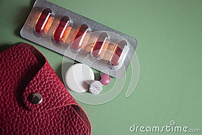 Pharmaceutical pills and medicine with brown leather wallet on mint background Stock Photo