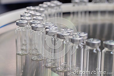 Pharmaceutical production line - conveyor belt with empty injection glass vials Stock Photo