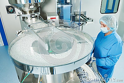 Pharmaceutics. Pharmaceutical worker operates tablet blister packaging machine Stock Photo