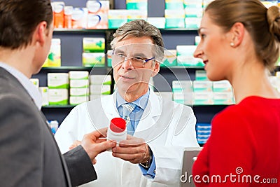 Pharmacist with customers in pharmacy Stock Photo