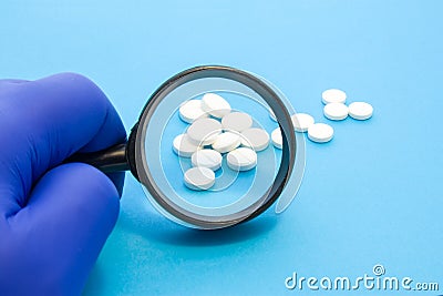 Pharmacist or expert on pharmaceutical inspection identifies pills. Testing, verification and determining pharmaceutical counterfe Stock Photo