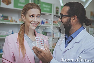 Pharmacist helping his female customer at drugstore Stock Photo