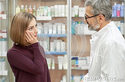 Pharmacist helping woman with tooth ache. Stock Photo