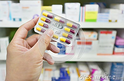 Pharmacist holding medicine capsule pack at the pharmacy drugstore Stock Photo