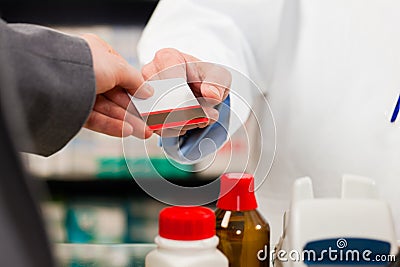 Pharmacist with paying customer in pharmacy Stock Photo