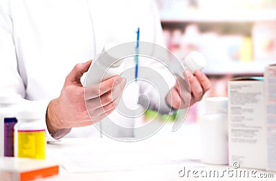 Pharmacist in pharmacy. Holding two bottles of pills. Stock Photo