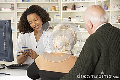 Pharmacist in pharmacy with senior couple Stock Photo