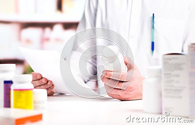 Pharmacist reading prescription with medicine and pill bottle Stock Photo