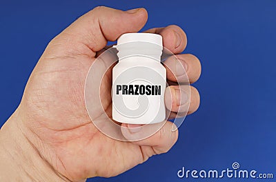 On a blue background in the hands of a man is a white jar with the inscription - Prazosin Stock Photo
