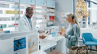 Pharmacy Drugstore Checkout Counter: Professional Black Male Pharmacist Provides Service, Sells Stock Photo