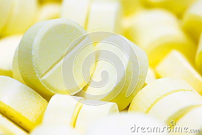 Pharmacy theme, Heap of yellow round medicine tablet antibiotic pills. Shallow DOF Stock Photo
