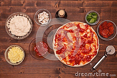 Phases of making a pizza - spreading tomato sauce on the dough Stock Photo