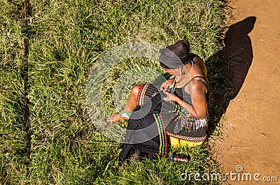 Zulu woman dressed in traditional gear sews her traditional dress. South Africa, african lifestyle Editorial Stock Photo