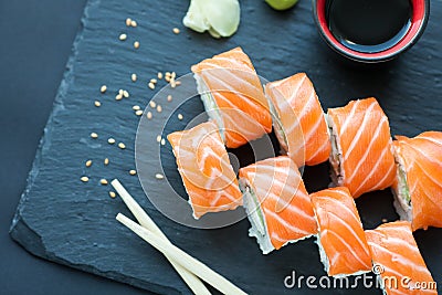 Philadelphia roll classic on a dark stone background. Philadelphia cheese, cucumber, avocado. Japanese sushi. Top view Stock Photo