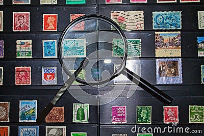 Philately magnifying glass and tweezers ready to see stamp collection Editorial Stock Photo